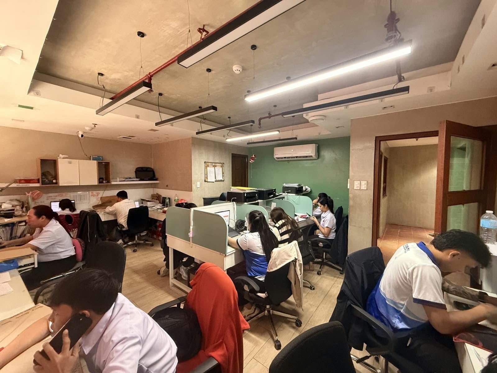 Team coordinating by phone and laptop at shared desks